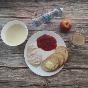 Zdjęcie przedstawia Dietę podstawową:  Kawa zbożowa z mlekiem Kasza manna na mleku Chleb mieszany pszenno-żytni Masło extra Dżem Twarożek różany Jabłko Woda źródlana